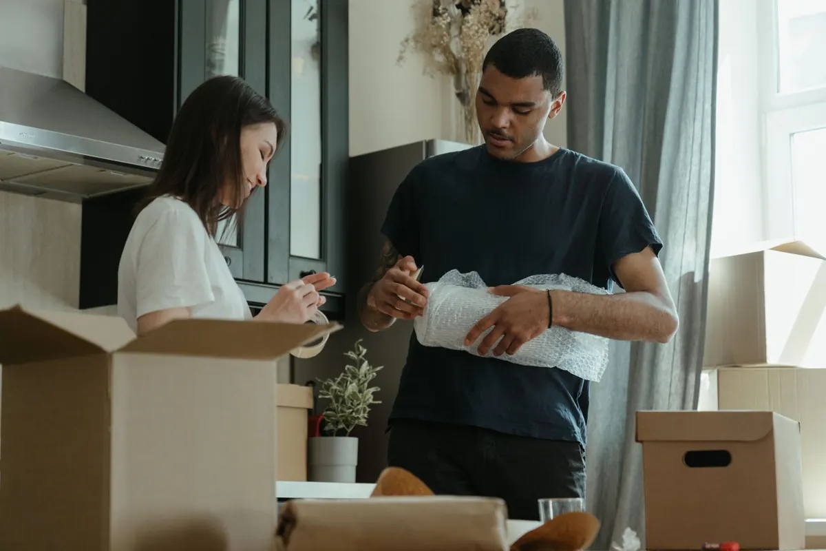Casal desembalando caixas no apartamento novo